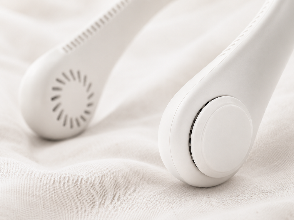 Close-up detail of BreezeLoop neck fan pods showing air intake grilles and soft silicone construction on linen fabric